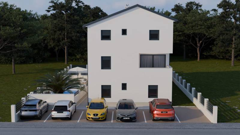 Parking lot by a 4-room apartment in Mandre with five cars in front of a white building.