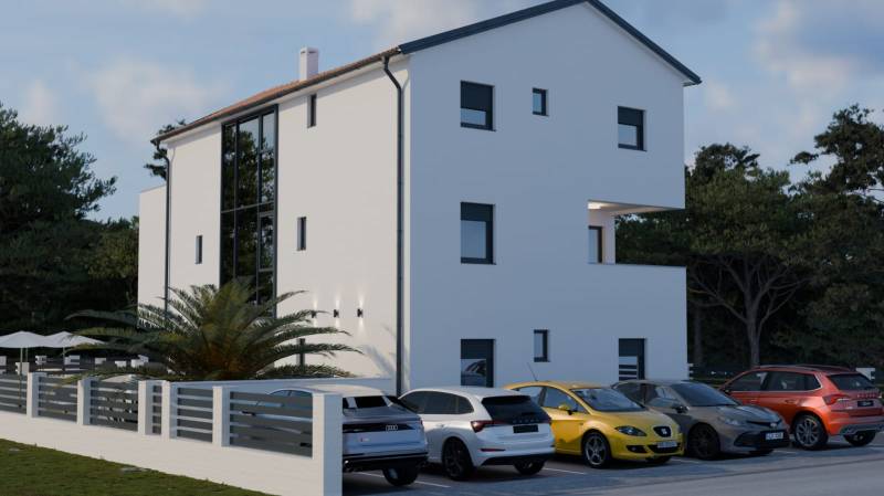 White building next to parked cars in Mandre, near the forest, for a 4-room apartment.