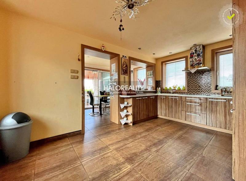 A kitchen in a family house with wooden furniture and ceramic tiles.