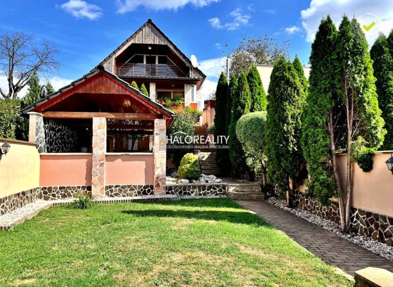 A family house in Levice with a landscaped garden, a gazebo, and trees.