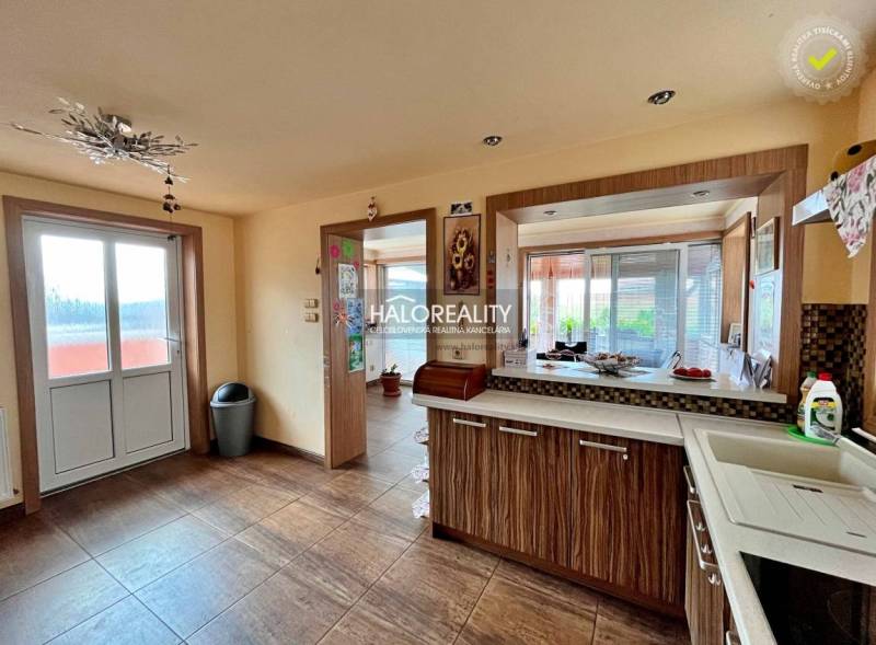 A kitchen in a family house with glass doors and a countertop with a wooden decor.
