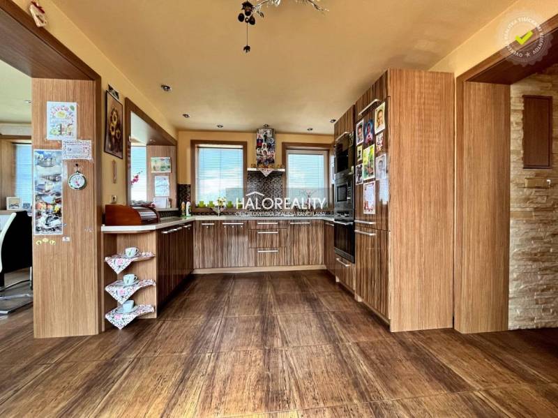 A kitchen in a family house with wooden cabinets and built-in appliances.