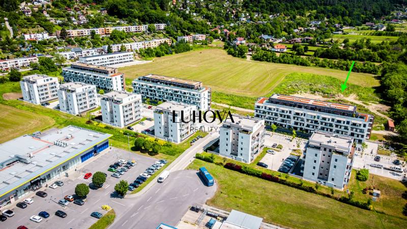 Aerial view of apartment buildings and a parking lot in Púchov on Dlhé lúky with a view of a 2-bedroom apartment.