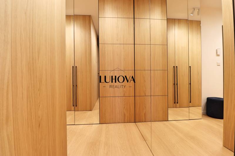 A wardrobe in a 2-room apartment with wooden cabinets and mirrors.