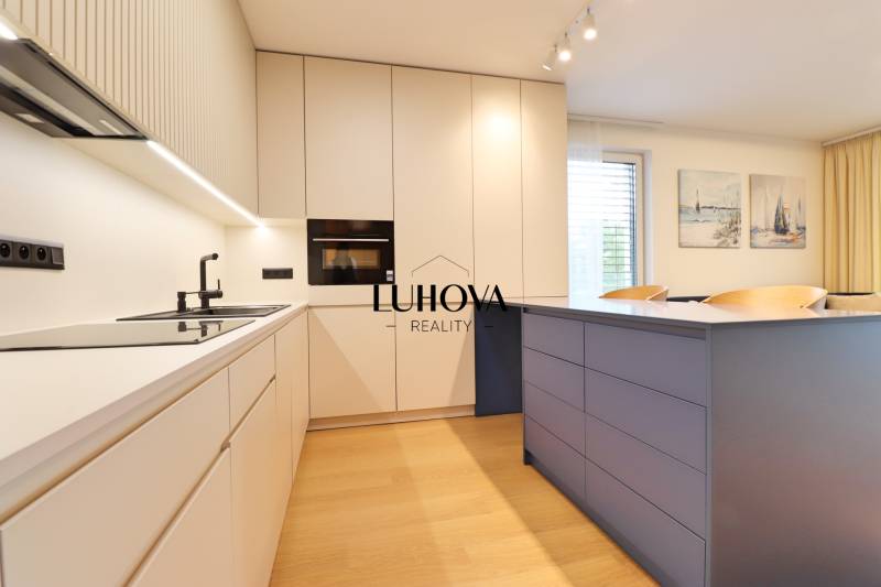 A modern kitchen in a 2-room apartment with an elegant countertop and light furniture.