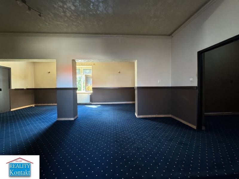 Interior of commercial premises with blue carpet and two rooms.