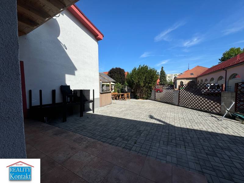 In the premises of the commercial spaces at Žerotínova Bašta in Nové Zámky, there is a paved area with furniture.