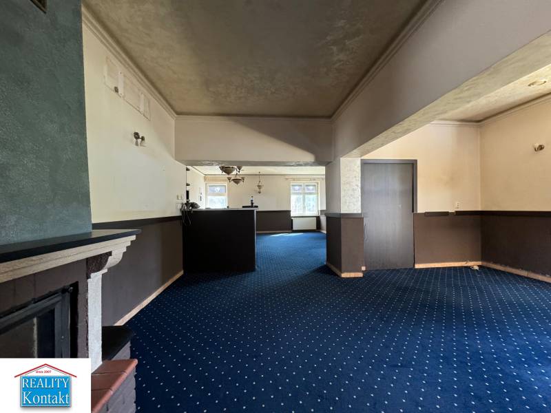 Interior of commercial spaces with blue carpet and ceiling lighting.