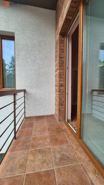 A balcony in a 5 or more room apartment with tiles and brick cladding.