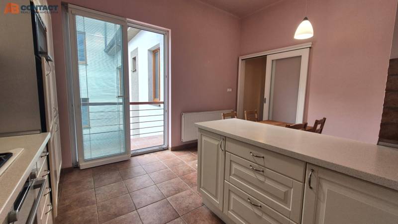 A kitchen with an island and balcony doors in a 5 or more room apartment.
