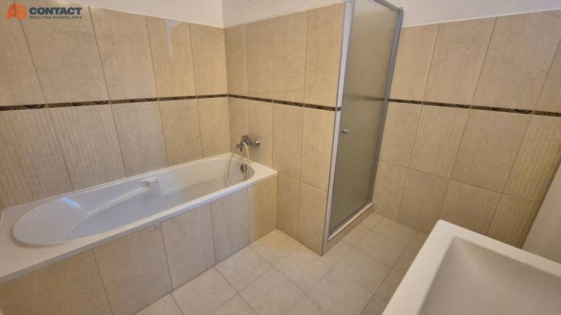 A bathroom in a 5 or more room apartment with a bathtub and a shower, beige tiles.