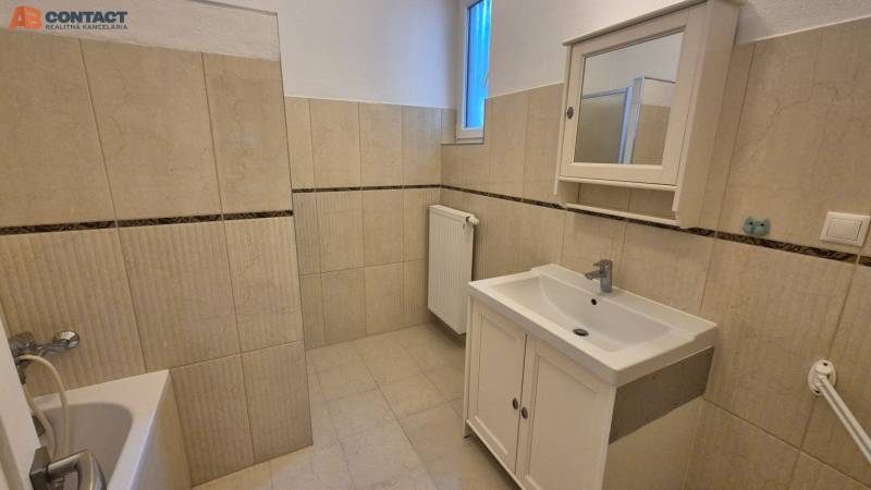 A bathroom with a bathtub and sink in a 5 or more room apartment in beige tones.