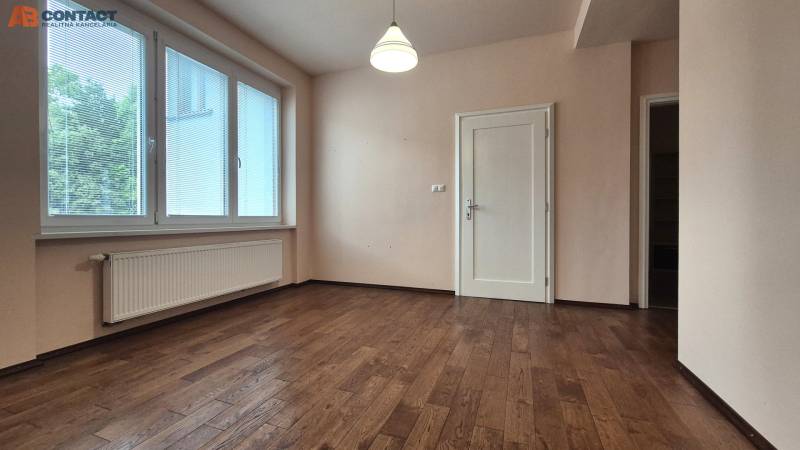 A room in a 5 or more room apartment with a wooden floor and a large window.
