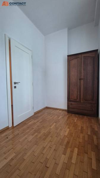Interior in a 5 or more room apartment with wooden flooring and a dark wardrobe.