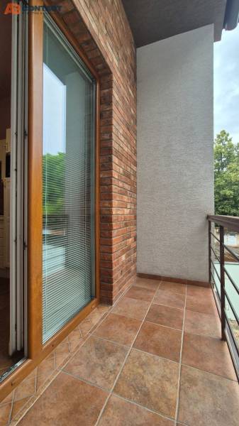 A balcony with a brick wall and glass doors in a five or more room apartment.