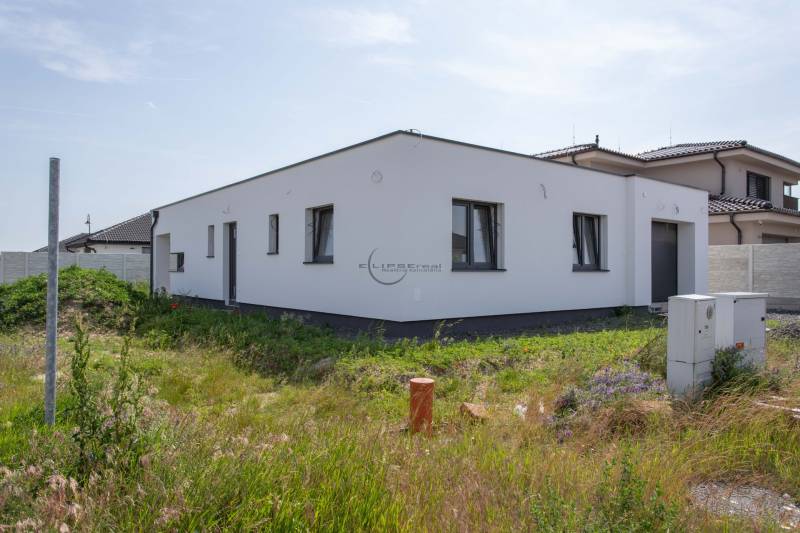 A family house in Zohor with a white facade and a garden on a sunny plot.