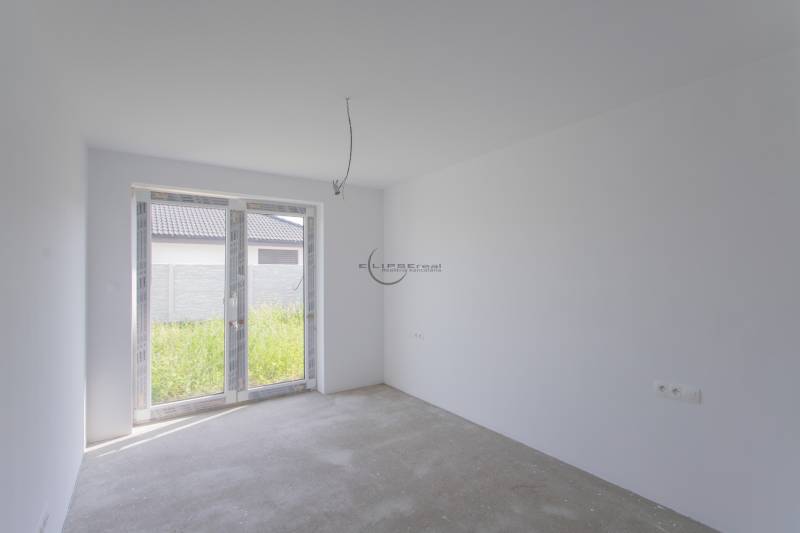 Empty room with white walls and glass doors in a family house.