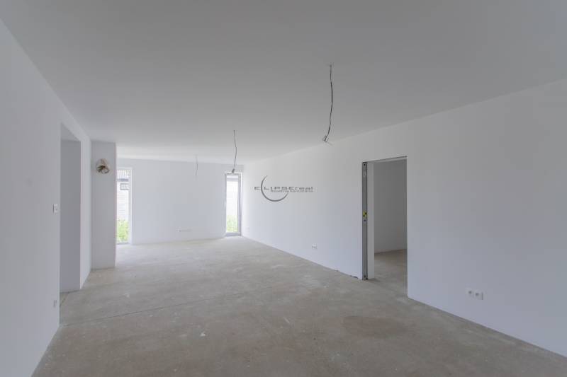 Bright, unfurnished room in a family house with white walls and ceiling.