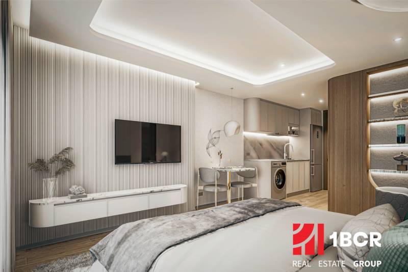 Interior with a kitchenette and television, part of apartment construction.