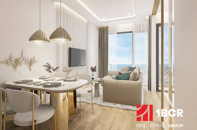 Interior of a 2-room apartment with an elegant dining table, sofa, and large windows.