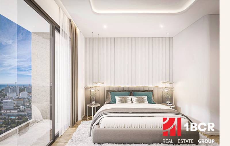A bedroom in a 2-room apartment with a view of the Pattaya city skyline.