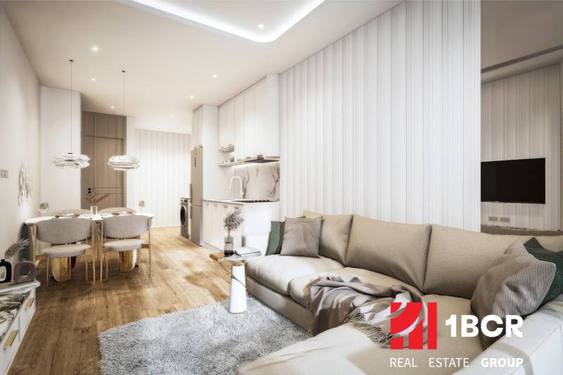 Living room with a kitchenette, sofa, and dining table in a three-room apartment.