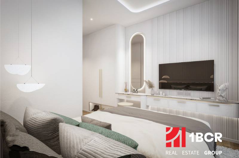 A bright bedroom with a bed and a mirror in a 3-room apartment, a TV on the wall.
