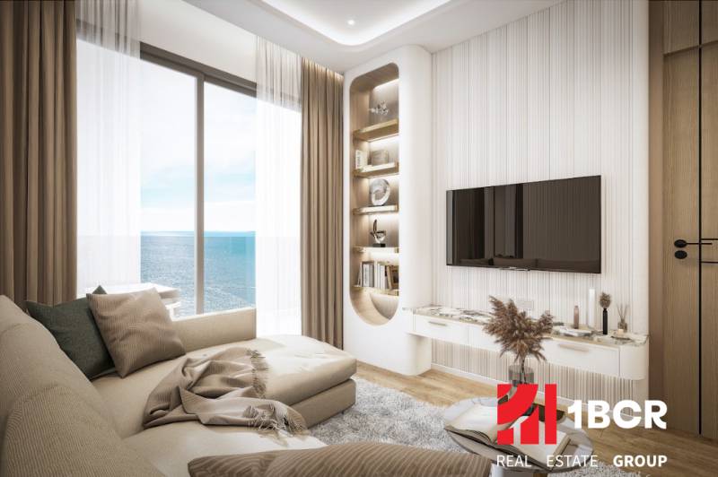 Living room in a 3-room apartment with a sea view, comfortable sofa, TV on the wall.