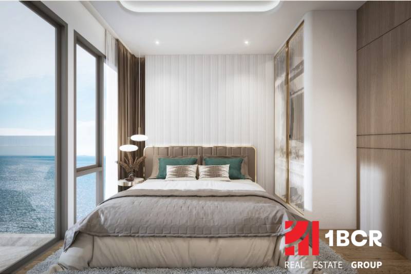 A bright bedroom with a large window and a sea view in a three-room apartment.