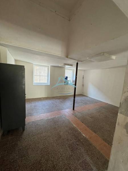 Free space in commercial premises with windows and a column in the middle of the room.
