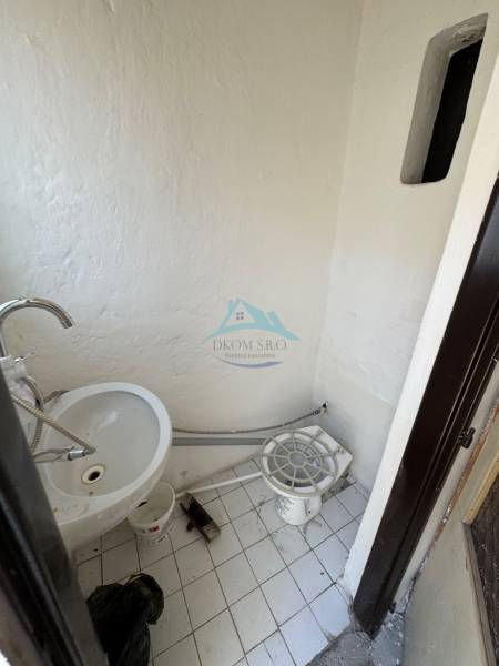 A small interior with a sink and white tiles in commercial premises.