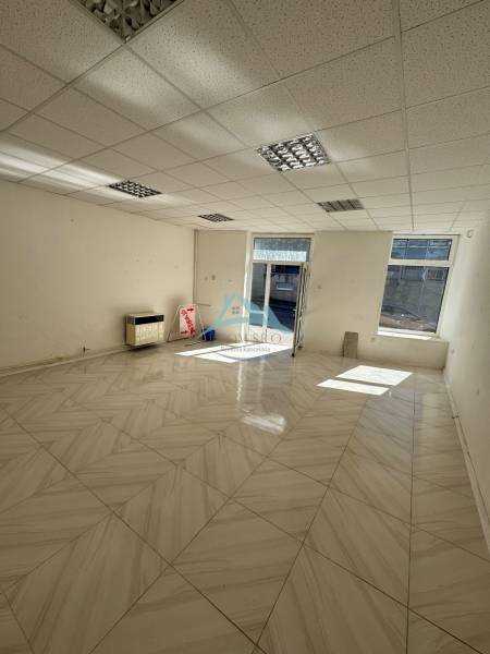 Commercial premises with large windows and tiled floors, spacious and bright.