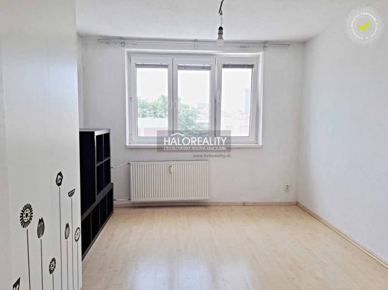 A studio apartment with white walls and windows matches the furniture and flooring.
