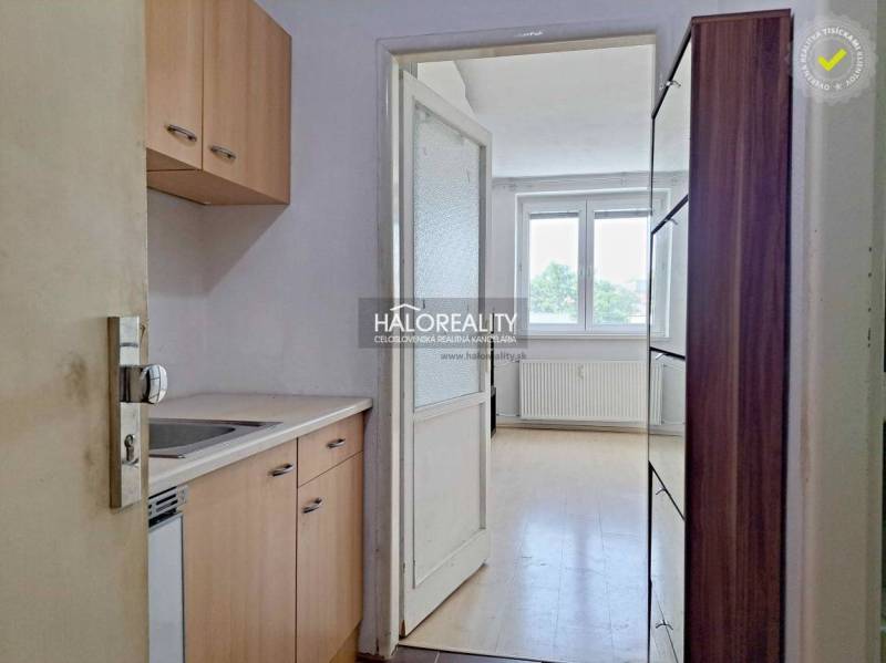 Studio apartment with a kitchenette and a large window, luminous walls and floors.