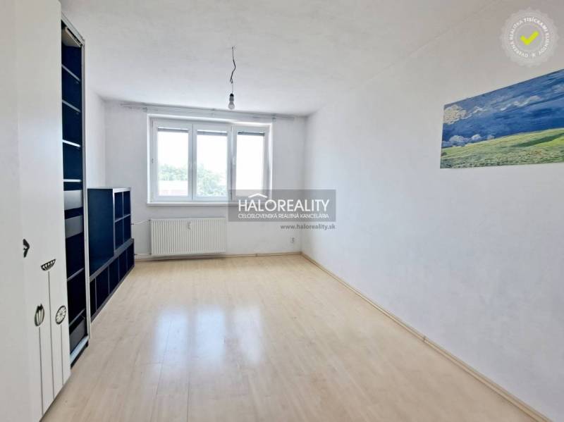 Spacious studio with white walls, wooden floor, and a large window.