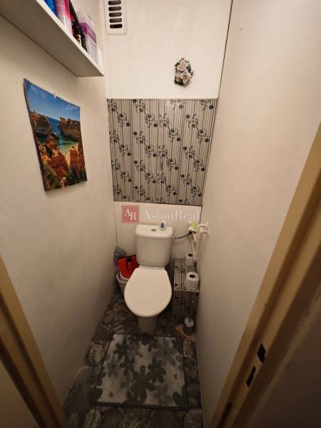 A bathroom with floral decoration and a calendar in a 2-room apartment.