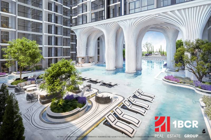 Apartment construction in Pattaya: pool, loungers, greenery, modern architecture, exterior, sunny location.