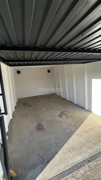 Empty garage with a concrete floor and a metal ceiling.