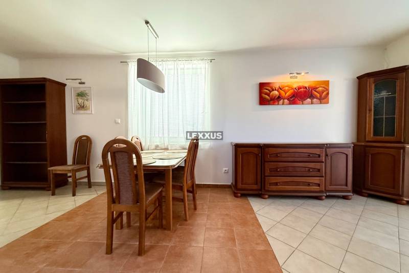 Dining area of a family house with wooden furniture and paintings.