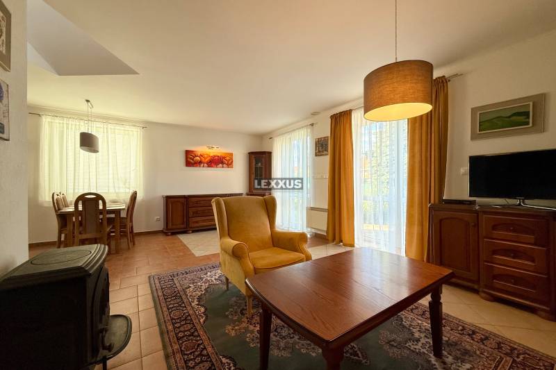 A living room in a family house with a comfortable armchair, a television, and a dining table.