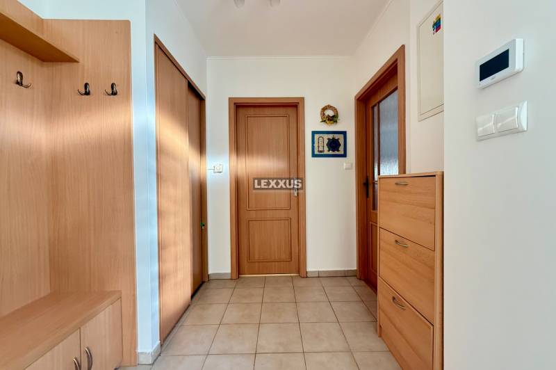 A hallway in a family house with wooden furniture and tiled flooring.