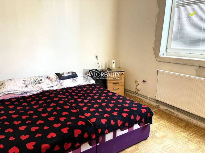 A bedroom in a family house with a bed and a nightstand, there are candles on the table.