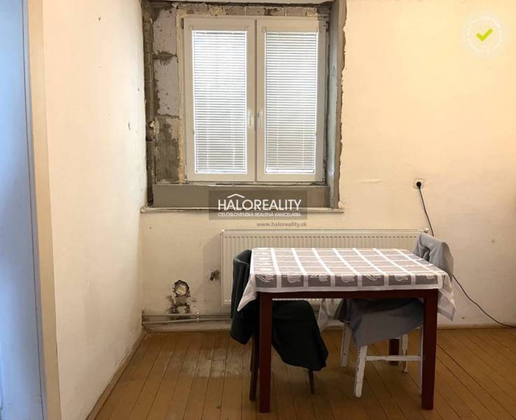 A room in a family house with a window, table, and chairs, simple interior.
