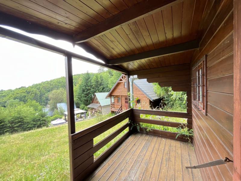 A wooden porch of a family house in Štefultov with a view of the wooded surroundings.