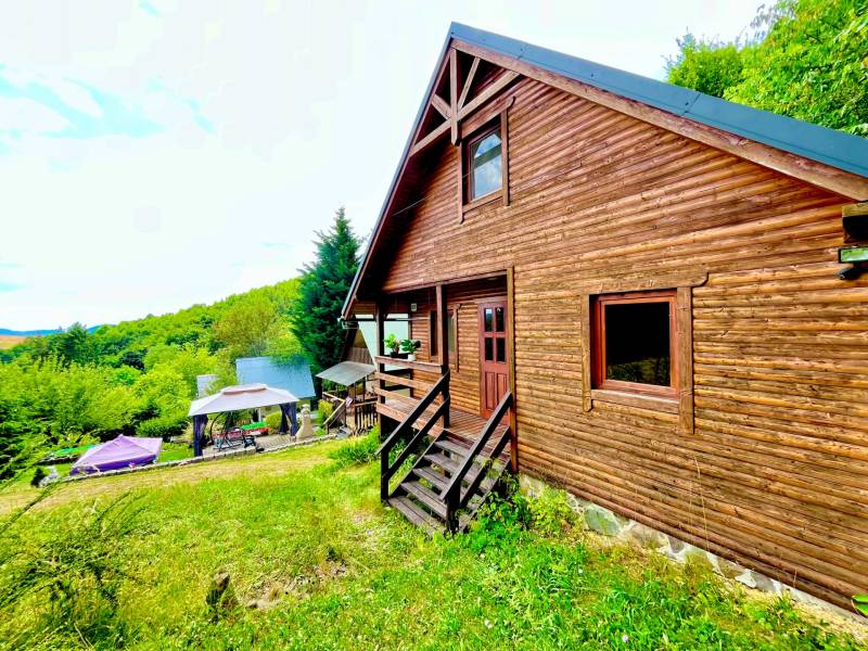 A wooden family house in Štefultov surrounded by forests, with a garden gazebo.