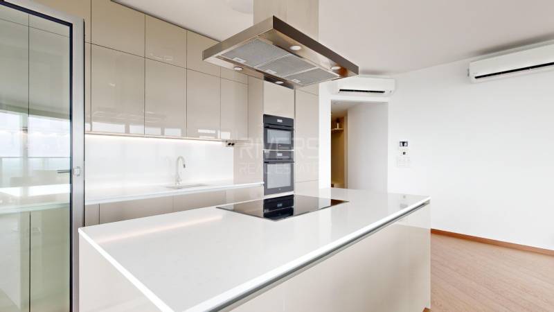 Spacious kitchen with a cooktop in a 4-room apartment with glass doors.