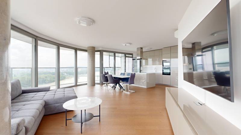 Bright living room in a 4-room apartment with large windows and a modern kitchen.