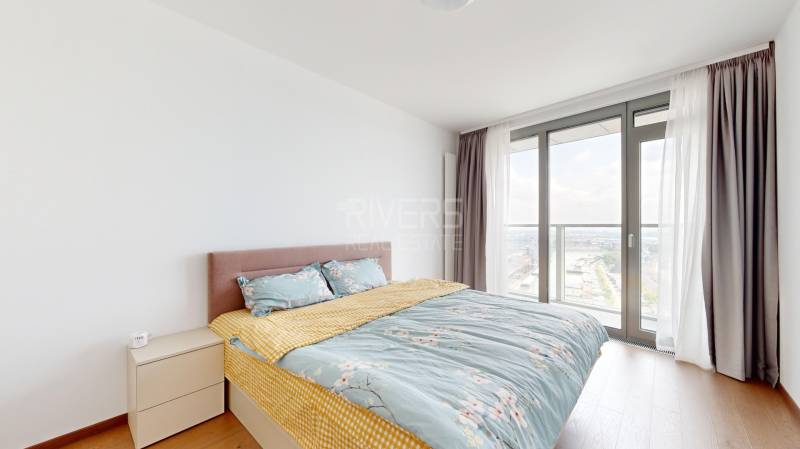 Bedroom in a 4-room apartment with a large window and a bed.