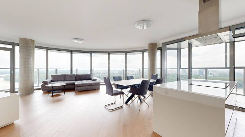 Living room with a round view, sofa, dining table, and glass walls in a 4-room apartment.
