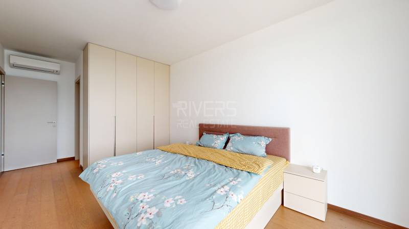 Bedroom in a 4-room apartment with a bed, wardrobe, and white walls.